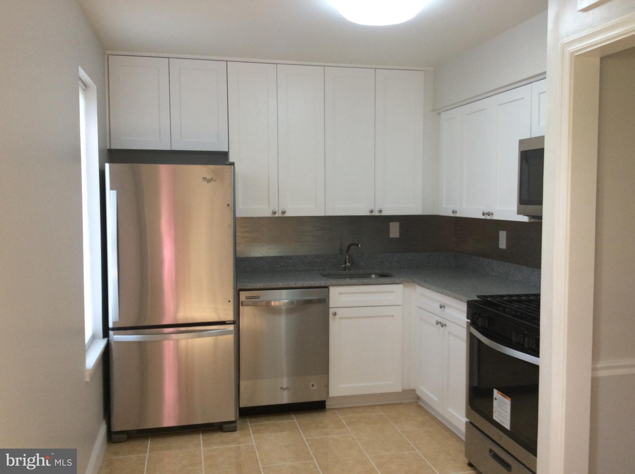 9633 White Acre Road, Unit A2 Columbia, MD 21045 - Photo 14 of 27 a kitchen with a refrigerator sink and cabinets