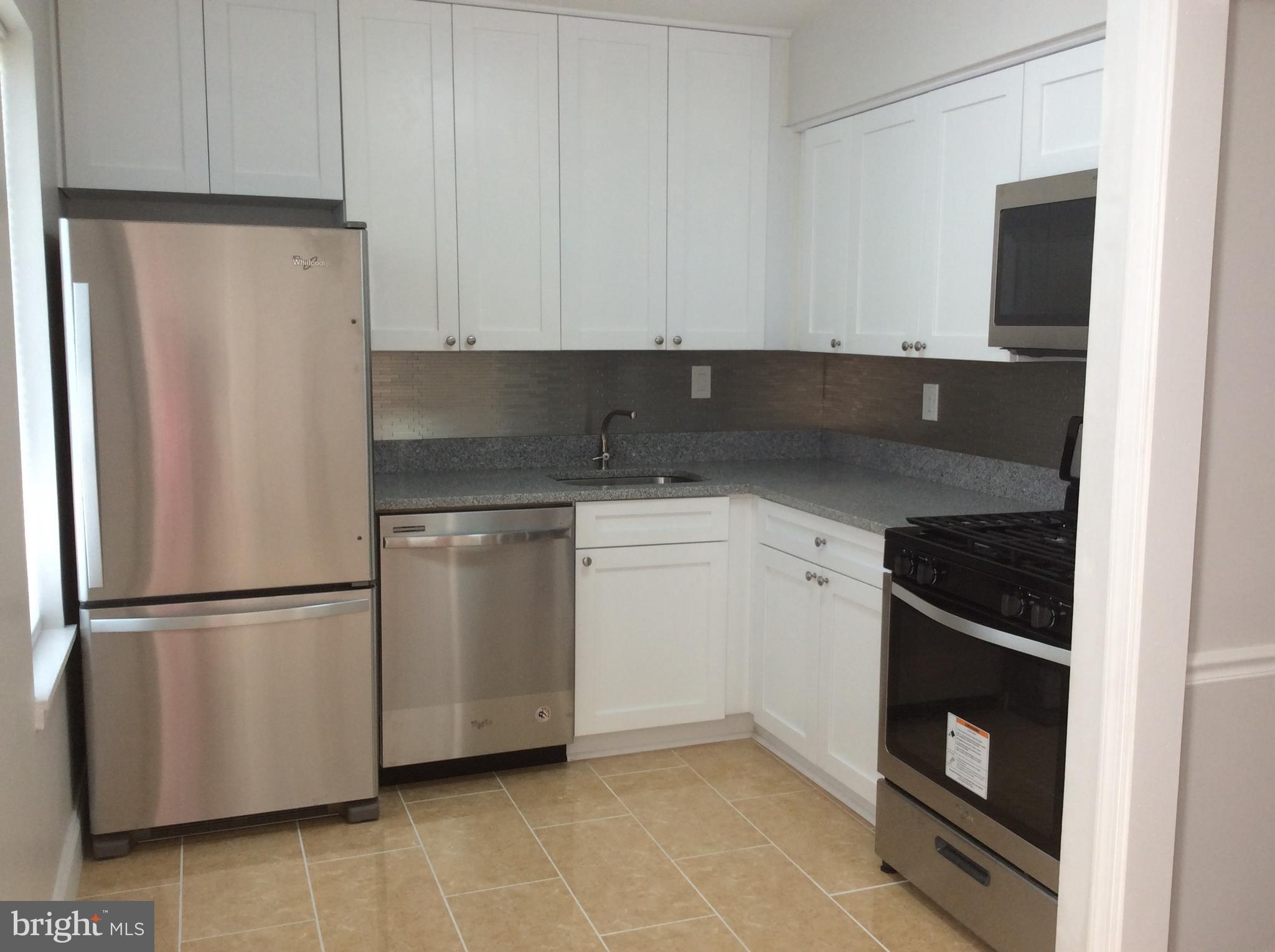 9633 White Acre Road, Unit A2 Columbia, MD 21045 - Photo 15 of 27 a kitchen with white cabinets and white appliances