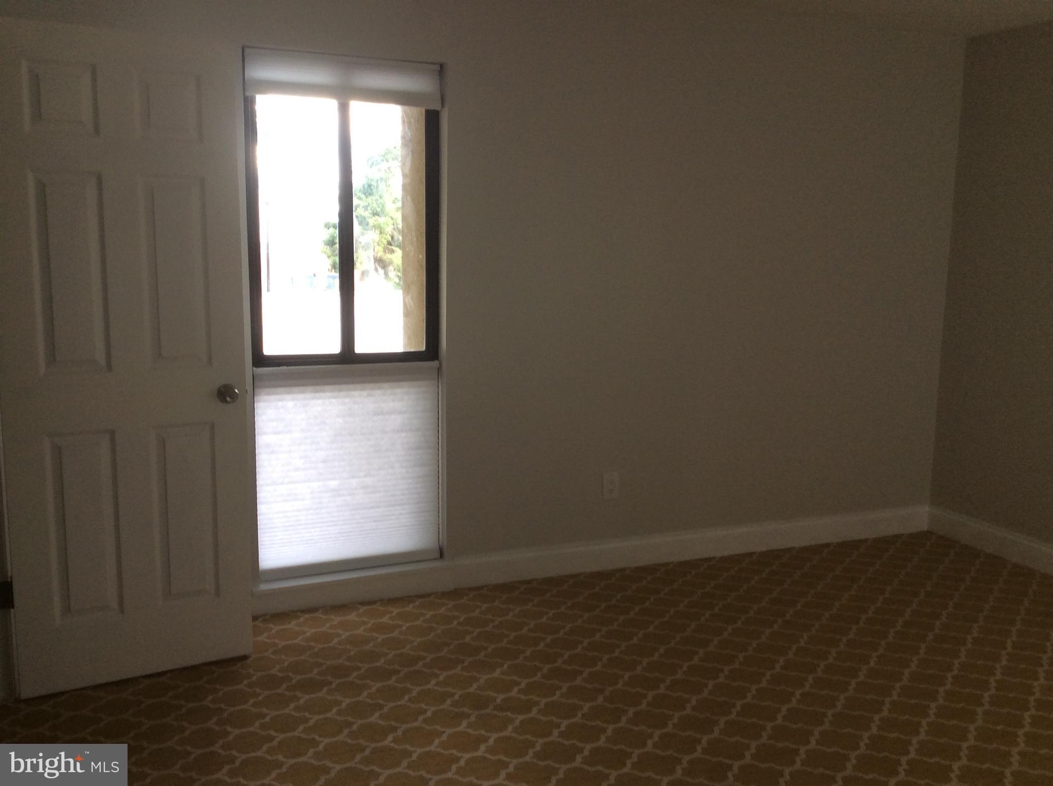 9633 White Acre Road, Unit A2 Columbia, MD 21045 - Photo 20 of 27 an empty room with wooden floor and windows