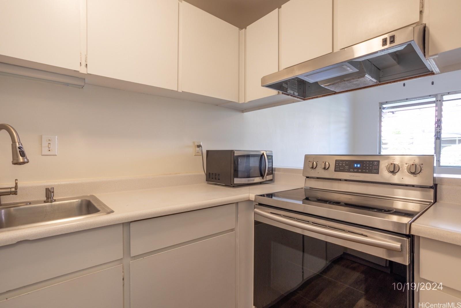 94-112 Anania Drive, Unit 219 Mililani, HI 96789 - Photo 12 of 25 a kitchen with appliances cabinets and a sink