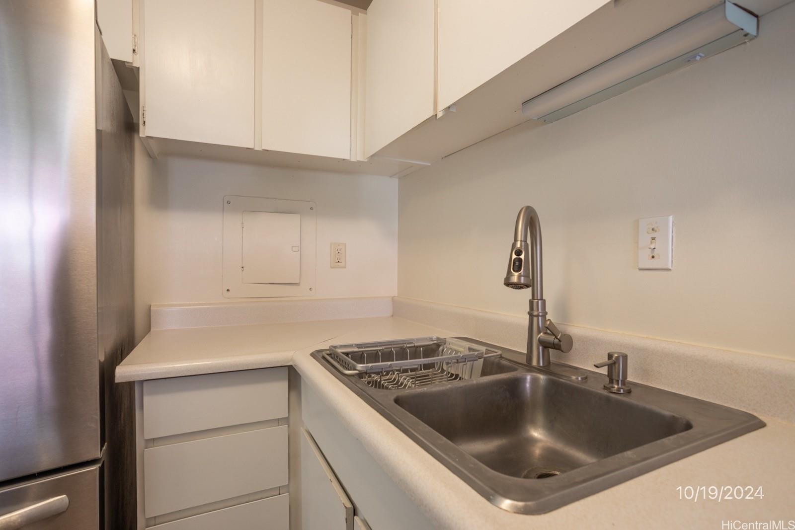 94-112 Anania Drive, Unit 219 Mililani, HI 96789 - Photo 13 of 25 a kitchen with kitchen island a sink stove and refrigerator