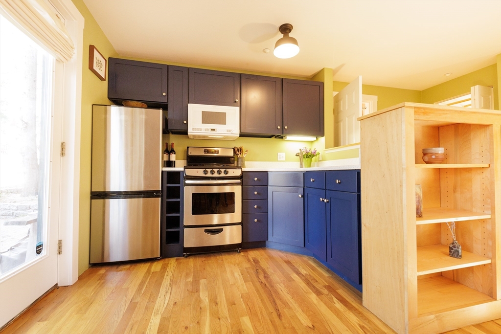 411 Norfolk Street, Unit 1F Somerville, MA 02143 - Photo 3 of 16 a kitchen with stainless steel appliances a refrigerator and a stove