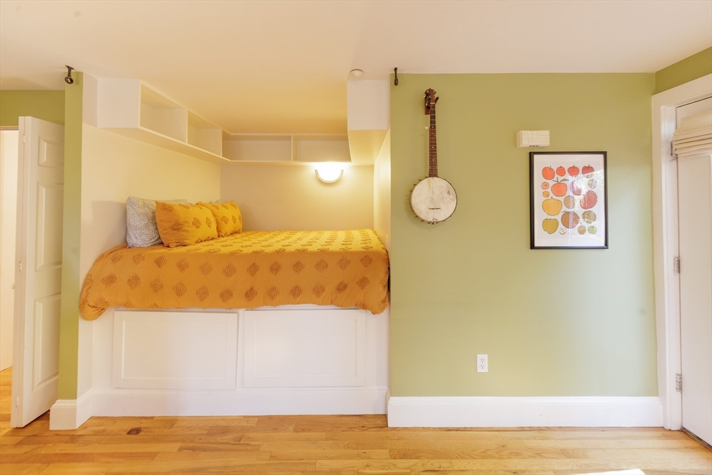 411 Norfolk Street, Unit 1F Somerville, MA 02143 - Photo 7 of 16 a bedroom with a bed and wooden floor