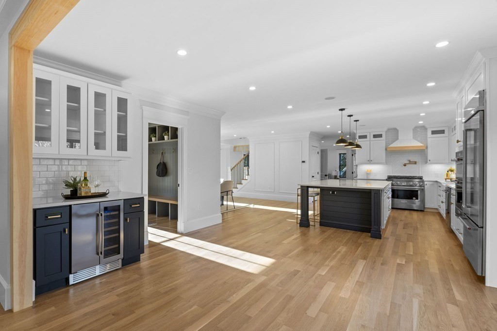 81 Sagamore Street Hamilton, MA 01982 - Photo 11 of 37 a kitchen with stainless steel appliances kitchen island granite countertop a stove a refrigerator a sink a dining table and chairs with wooden floor