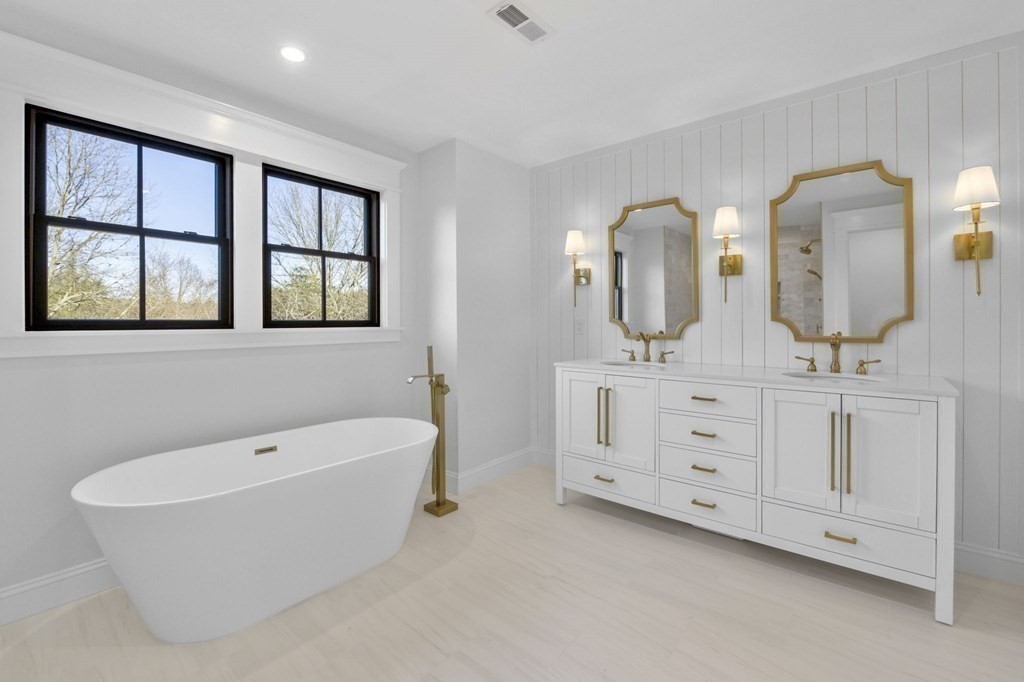 81 Sagamore Street Hamilton, MA 01982 - Photo 23 of 37 a bathroom with a double vanity sink a two mirror a window and a bathtub