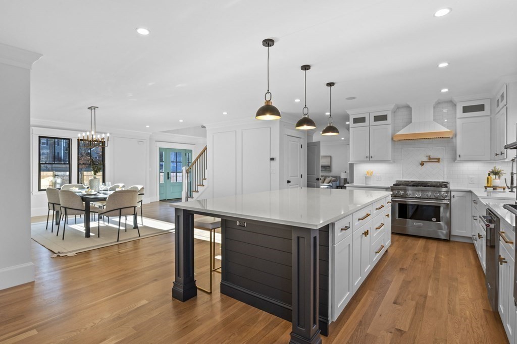 81 Sagamore Street Hamilton, MA 01982 - Photo 7 of 37 a kitchen with stainless steel appliances kitchen island granite countertop a stove a sink and a wooden floors