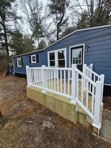 a view of a house with a yard and sitting area