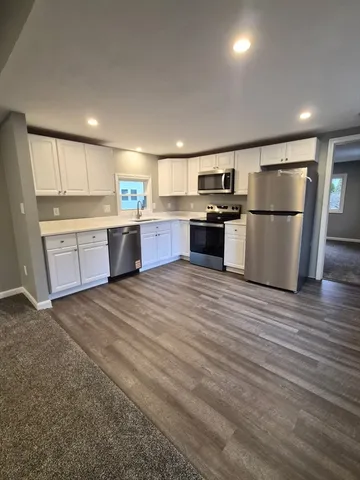 a kitchen with stainless steel appliances granite countertop a refrigerator sink and stove