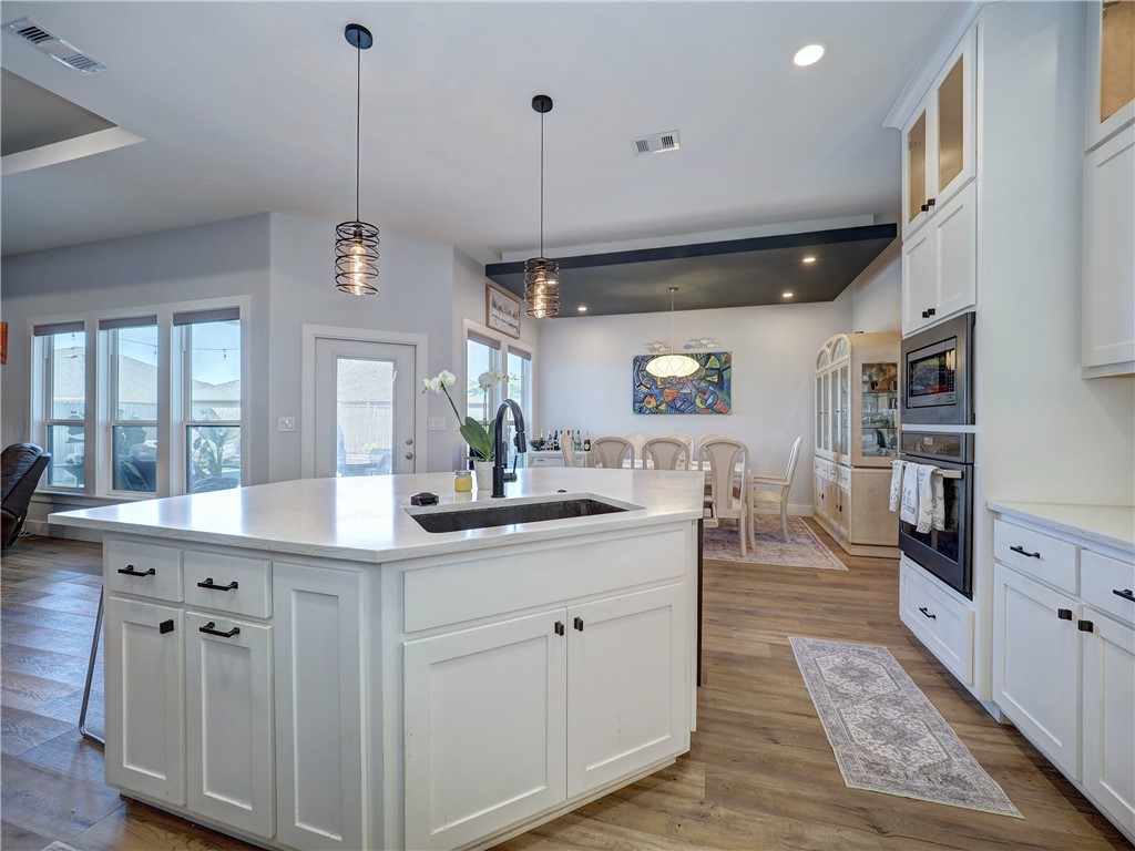 16101 Jessamine Street Corpus Christi, TX 78418 - Photo 15 of 29 a kitchen with stainless steel appliances kitchen island granite countertop a stove a sink and a wooden floors