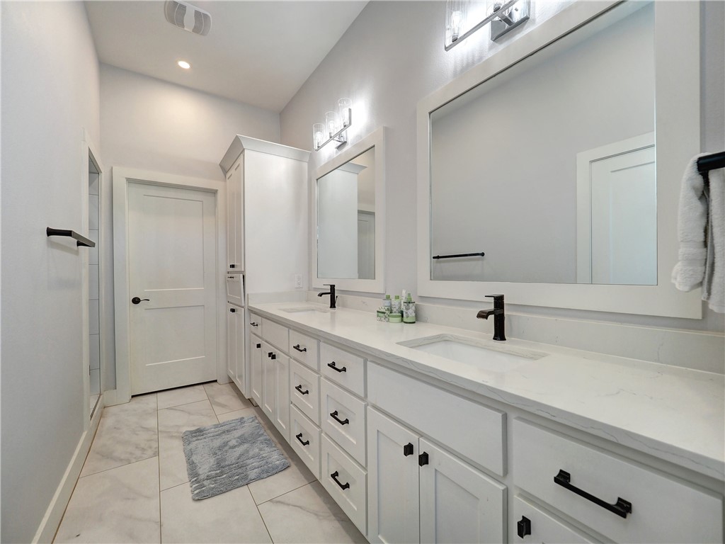16101 Jessamine Street Corpus Christi, TX 78418 - Photo 24 of 29 a bathroom with a double vanity sink and mirror