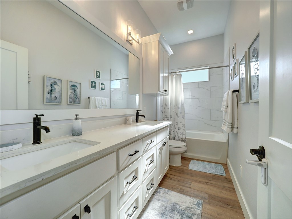 16101 Jessamine Street Corpus Christi, TX 78418 - Photo 27 of 29 a bathroom with a double vanity sink toilet mirror and shower