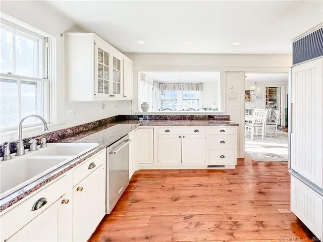 a large kitchen with granite countertop a sink and cabinets