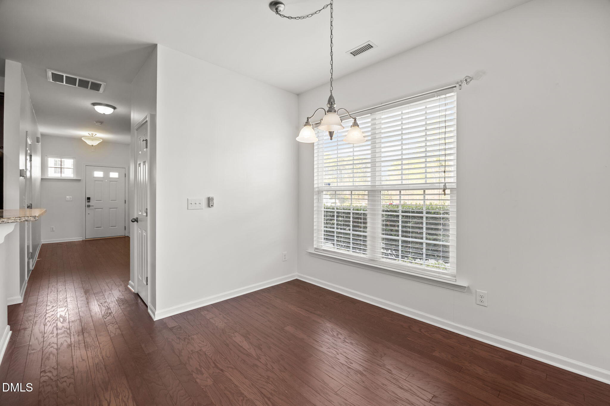 401 Stone Flower Lane Raleigh, NC 27603 - Photo 10 of 28 a view of an empty room with wooden floor and a window