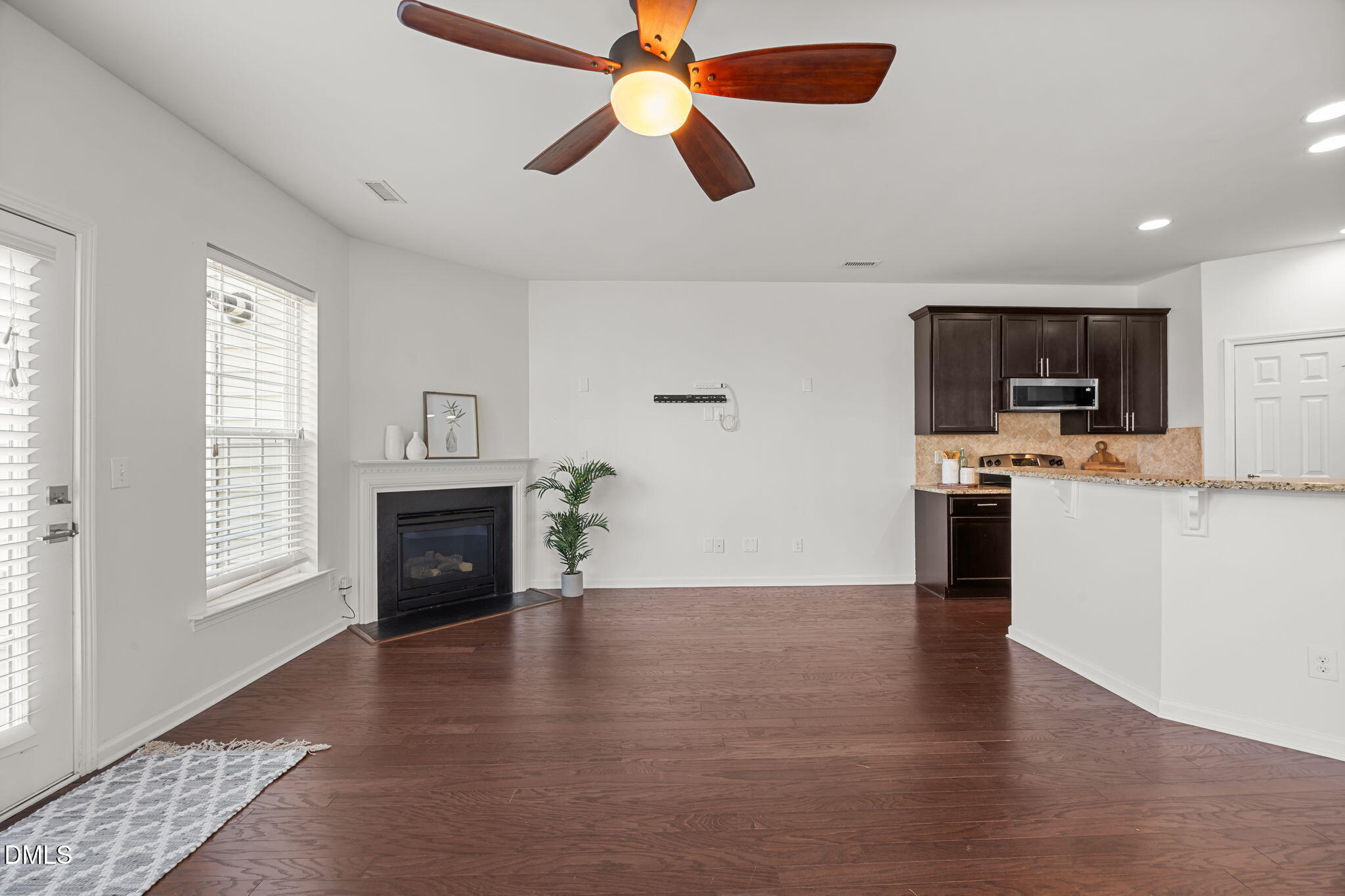 401 Stone Flower Lane Raleigh, NC 27603 - Photo 8 of 28 a open kitchen with granite countertop a stove top oven a sink dishwasher and a fireplace with wooden floor