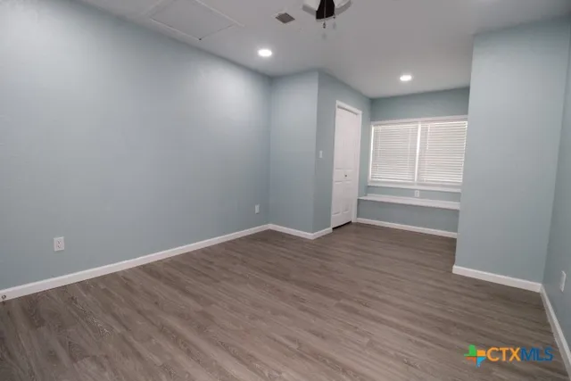 a view of an empty room with wooden floor