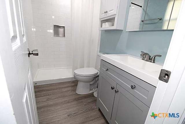 a bathroom with a sink a toilet and shower