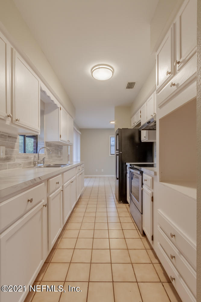 7447 Wheat Road Jacksonville, FL 32244 - Photo 12 of 42 a large white kitchen with a stove a sink and a refrigerator