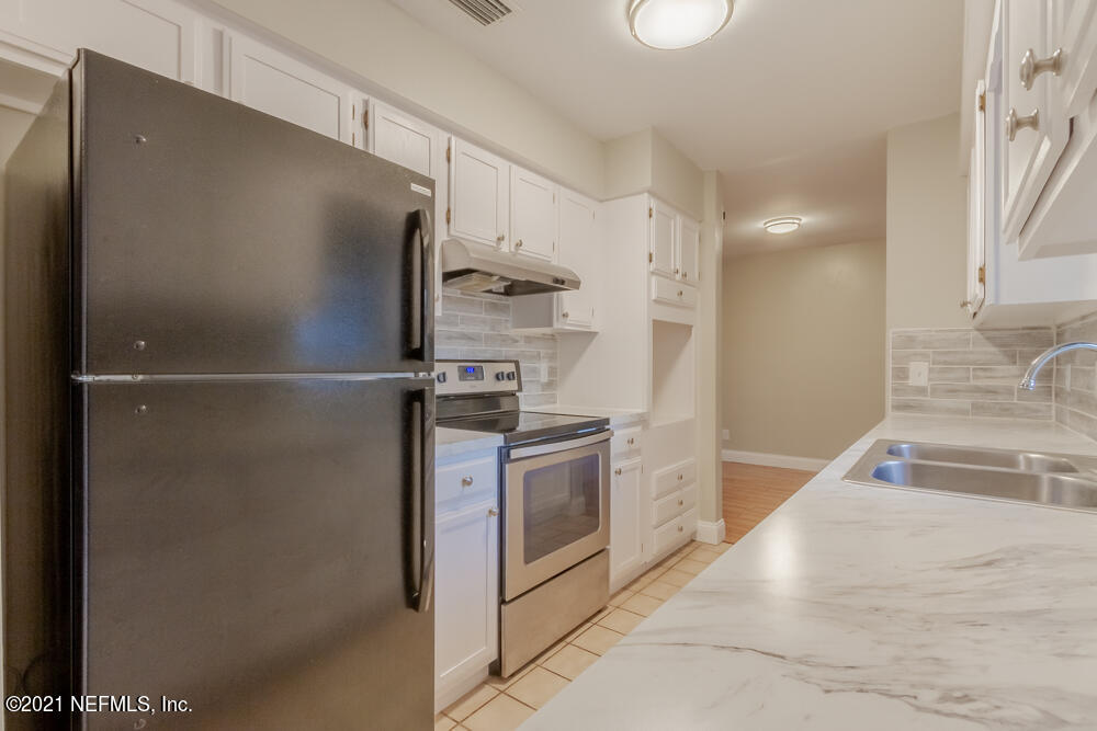 7447 Wheat Road Jacksonville, FL 32244 - Photo 13 of 42 a kitchen with a refrigerator and a sink
