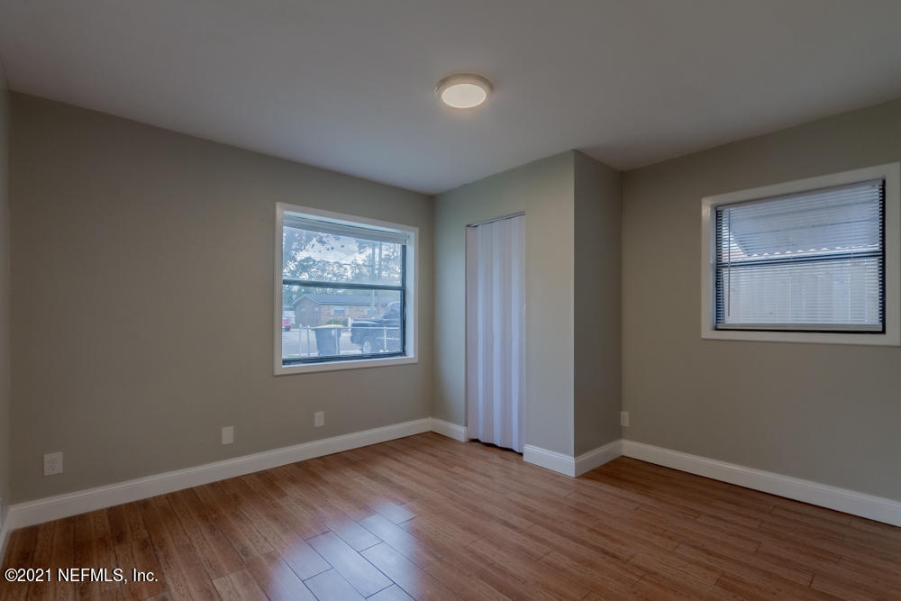 7447 Wheat Road Jacksonville, FL 32244 - Photo 22 of 42 a view of an empty room with wooden floor and a window