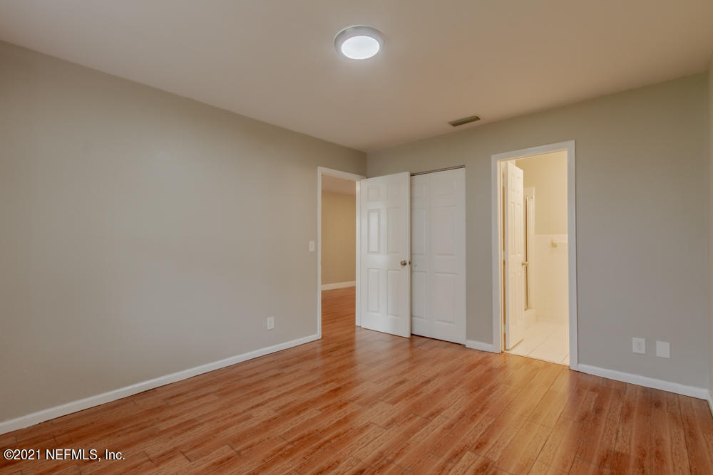 7447 Wheat Road Jacksonville, FL 32244 - Photo 28 of 42 a view of an empty room with wooden floor and a window