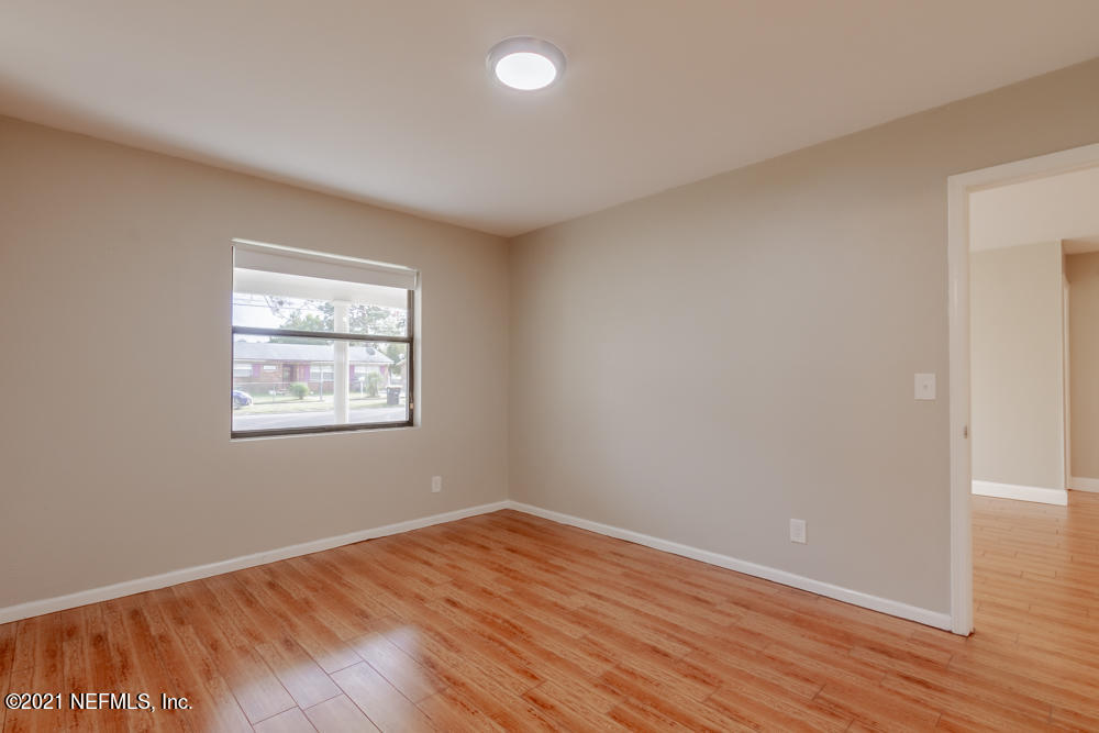 7447 Wheat Road Jacksonville, FL 32244 - Photo 29 of 42 an empty room with wooden floor and windows