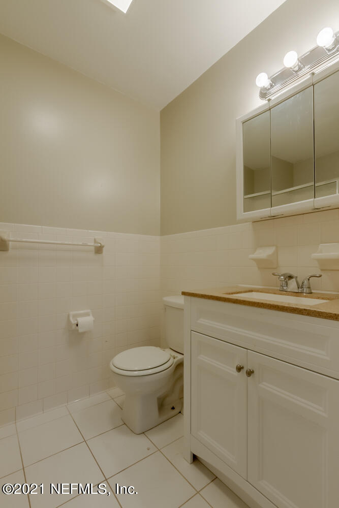 7447 Wheat Road Jacksonville, FL 32244 - Photo 30 of 42 a bathroom with a toilet a sink and mirror