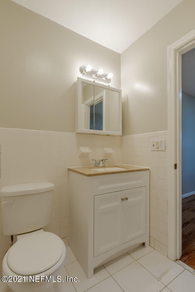 7447 Wheat Road Jacksonville, FL 32244 - Photo 33 of 42 a bathroom with a granite countertop toilet sink and mirror