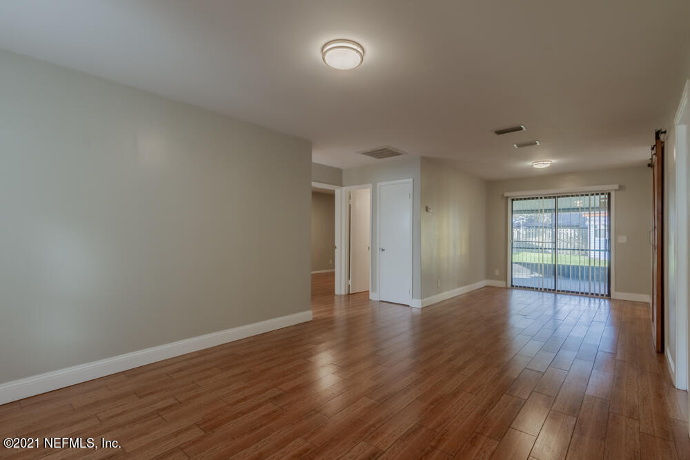 7447 Wheat Road Jacksonville, FL 32244 - Photo 6 of 42 a view of an empty room with wooden floor and a window