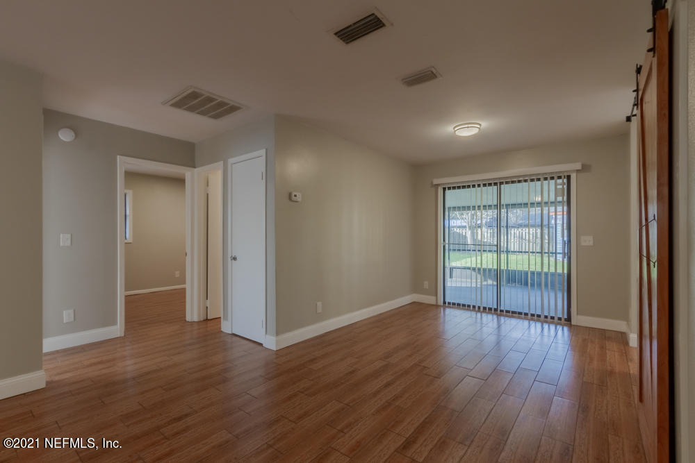 7447 Wheat Road Jacksonville, FL 32244 - Photo 8 of 42 an empty room with wooden floor and windows