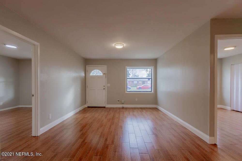 7447 Wheat Road Jacksonville, FL 32244 - Photo 10 of 42 an empty room with wooden floor and windows