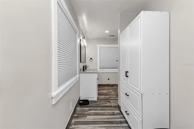 a view of a yard with plants and a large tree