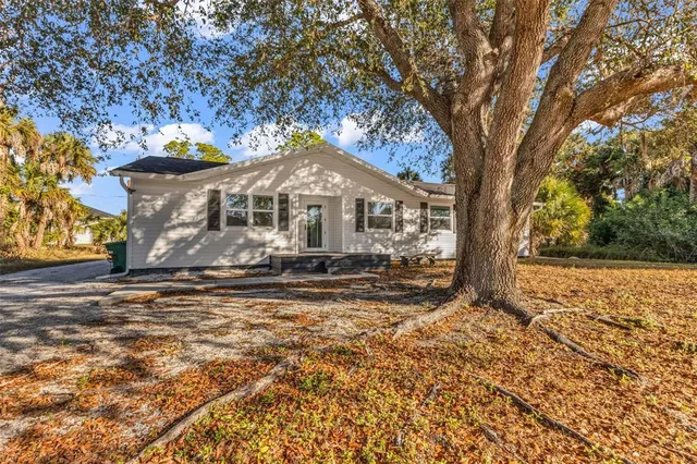 an aerial view of residential houses with outdoor space and trees