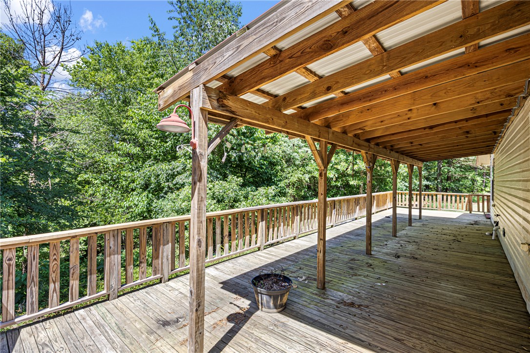 655 Charton Road Morrilton, AR 72110 - Photo 27 of 49 Expansive wooden deck featuring a full-length covered patio, wood railing, and exterior wall siding