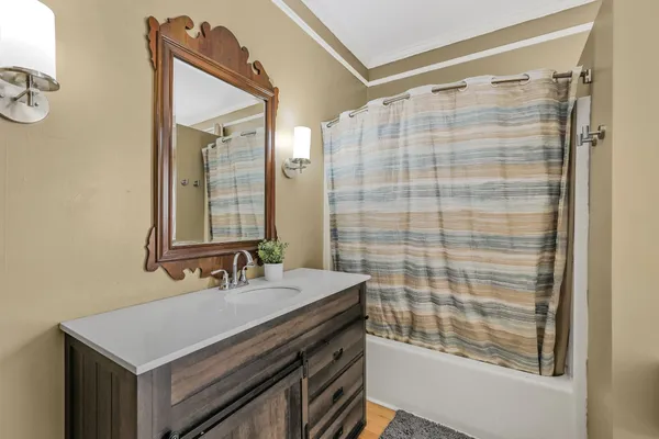 a bathroom with a sink mirror and a shower