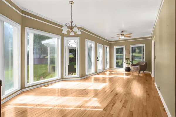 a view of a livingroom with wooden floor and a chandelier