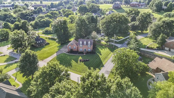 an aerial view of a house with a yard and swimming pool