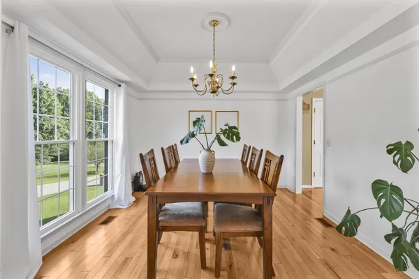 a view of a dining room with furniture a chandelier and wooden floor