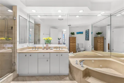 a bathroom with a granite countertop bathtub a sink and a shower