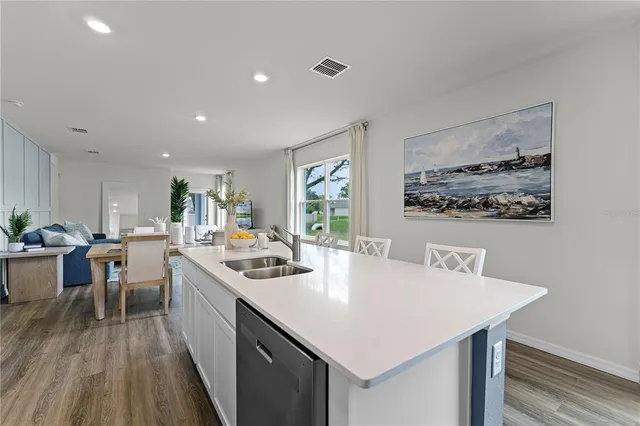 a kitchen with a sink a stove a dining table and chairs