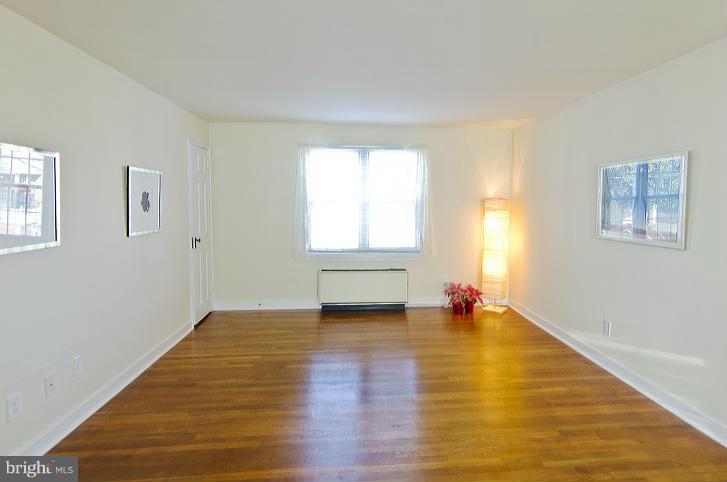 211 East Glebe Road, Unit B Alexandria, VA 22305 - Photo 3 of 15 a view of an empty room with wooden floor and a window