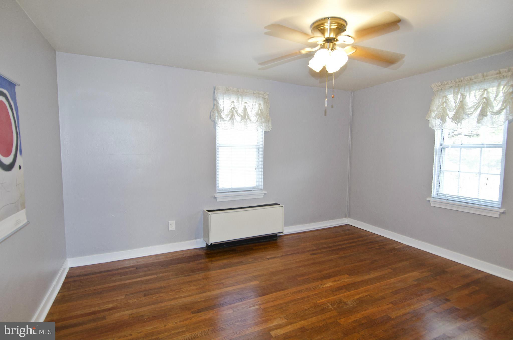 211 East Glebe Road, Unit B Alexandria, VA 22305 - Photo 10 of 15 an empty room with wooden floor chandelier fan and windows