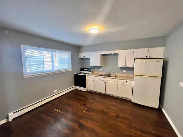a kitchen with granite countertop white cabinets and white appliances