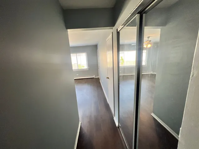 a view of a hallway with wooden floor
