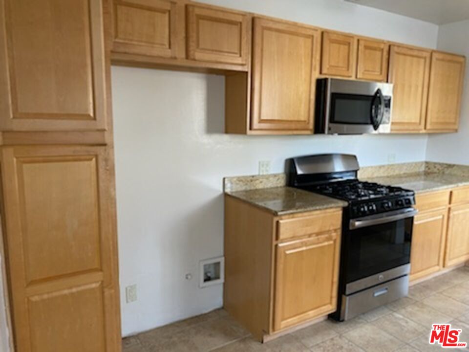 17600 Calvert Street Encino, CA 91316 - Photo 2 of 21 a kitchen with stainless steel appliances granite countertop white cabinets and a stove top oven