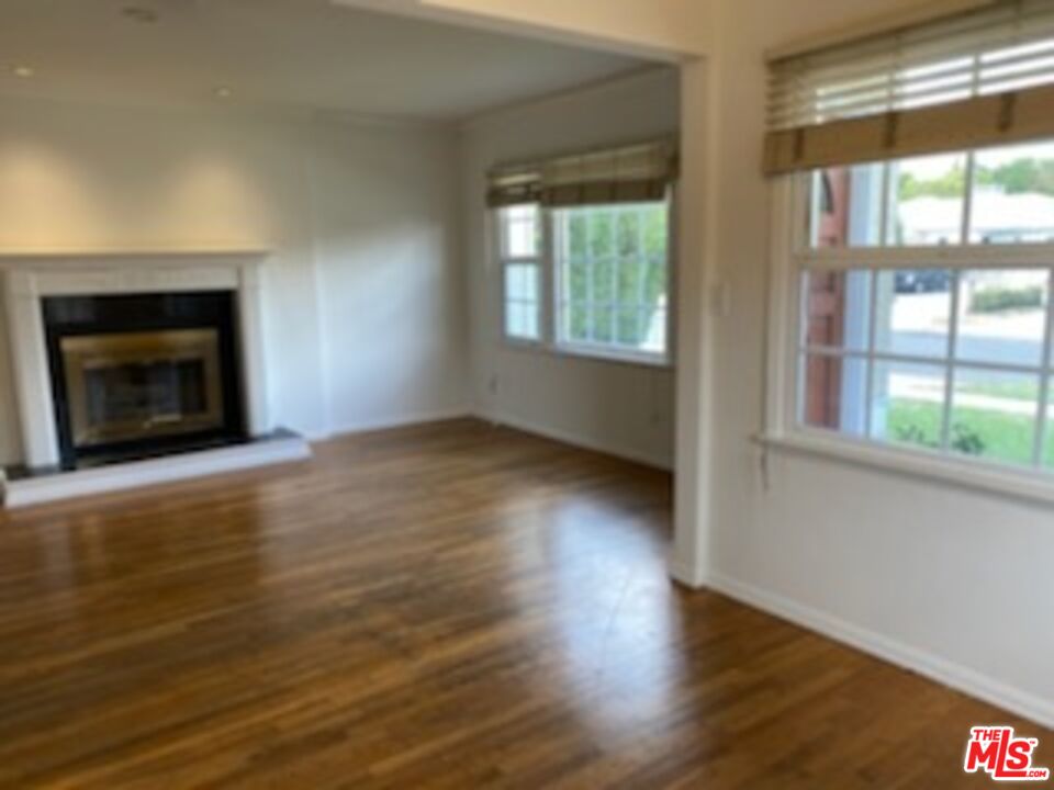 17600 Calvert Street Encino, CA 91316 - Photo 21 of 21 an empty room with wooden floor fireplace and windows