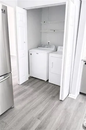 a view of a kitchen with refrigerator and wooden floor