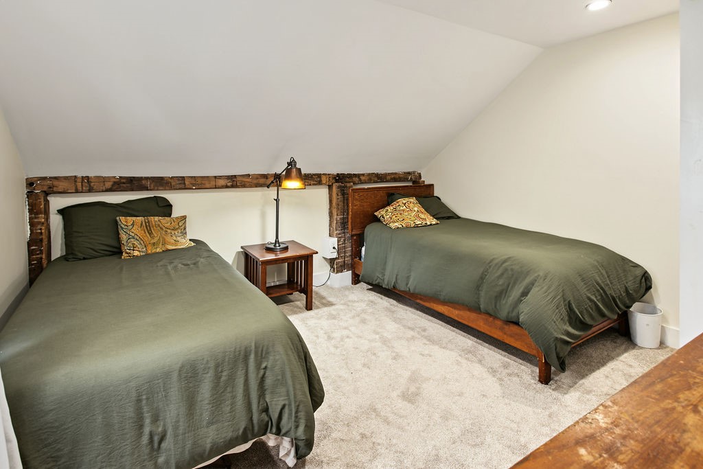 1668 Vandervort Hill Road Unadilla, NY 13849 - Photo 23 of 50 Exposed rustic wooden beams trace the sloped ceiling of this cozy carpeted space.