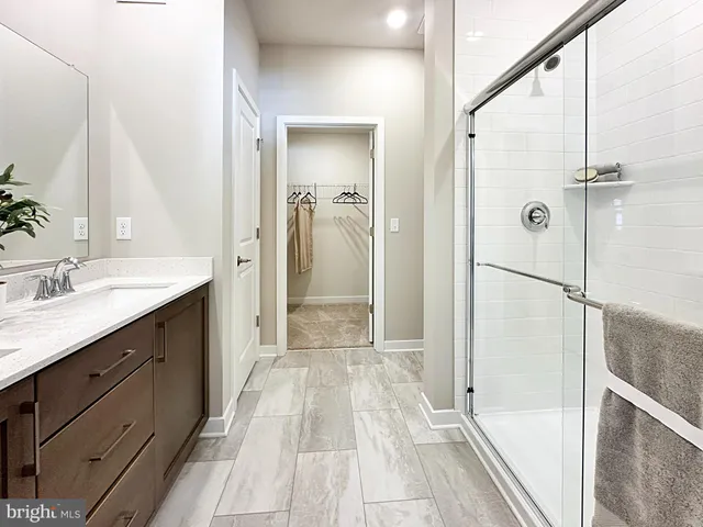 a spacious bathroom with a shower sink and mirror