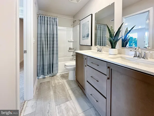 a spacious bathroom with a double vanity sink mirror and toilet