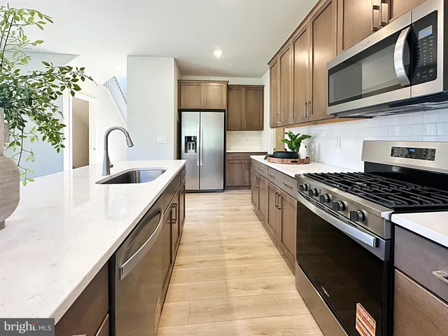 a kitchen with stainless steel appliances granite countertop a stove a sink dishwasher and a microwave